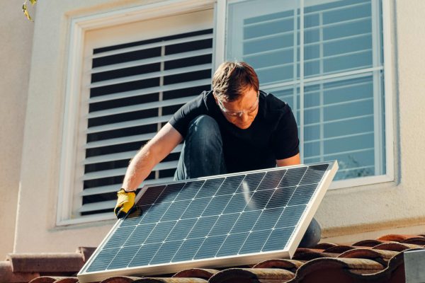 Man in Black Shirt Sitting on Brown Roof